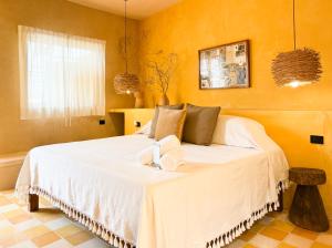 a bedroom with a large white bed in a room at Kuka y Letras in Mérida