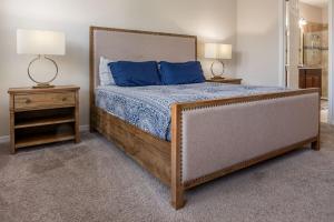 ein Schlafzimmer mit einem Bett mit blauen Kissen und zwei Lampen in der Unterkunft Luxury and Spacious Villa with Pool and Hot Tub just minutes from Disney in Kissimmee + 90 Fotos