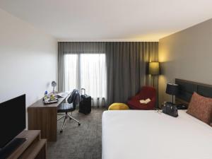 una camera d'albergo con un letto e una scrivania di Novotel Sydney International Airport a Sydney