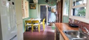 eine Küche mit Tisch und Stühlen und einer Spüle in der Unterkunft Redruth - 2 bedroom cottage situated in wandiligong in Wandiligong