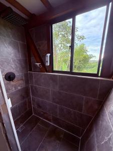 ein Bad mit einer Dusche und einem Fenster in der Unterkunft Finca de Descanso El Ocaso in Sevilla