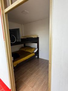 Kleines Zimmer mit einem Etagenbett und einer Mikrowelle. in der Unterkunft Finca de Descanso El Ocaso in Sevilla