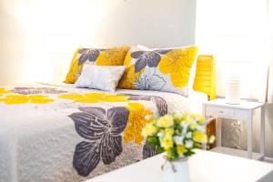 a bedroom with a bed with a flowered blanket and flowers at Honolulu Studio City Vibez in Honolulu