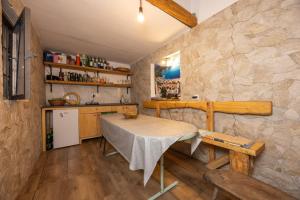 a kitchen with a table and a stone wall at Apartment Igrane 311b in Igrane