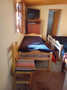 a bedroom with two twin beds and a tv at Casa de campo Villa El Perchel in Huacalera