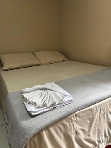 Giường trong phòng chung tại Quarto Confortável