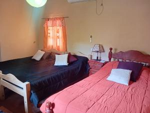 a bedroom with two beds and a window at Casa de campo Villa El Perchel in Huacalera +18 photos