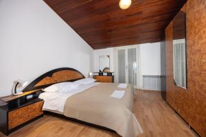a bedroom with a large bed with a wooden headboard at Apartments by the sea Igrane, Makarska - 311 in Igrane