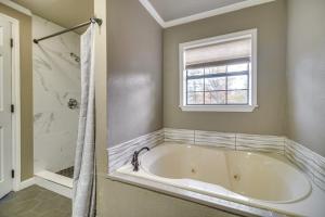 une baignoire blanche dans une salle de bain avec une fenêtre dans l'établissement Private Dock Grand Lake Family Home, à Eucha 25 autres photos