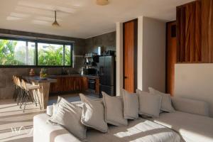 ein Wohnzimmer mit Couch und Küche in der Unterkunft Casa Hormiga · Refugio c/vista al mar y Alberca in Puerto Escondido