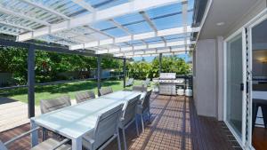 a patio with a white pergola and a table and chairs at Copa Beach House - Family in Copacabana