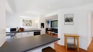a kitchen with white walls and a black counter top at Copa Beach House - Family in Copacabana