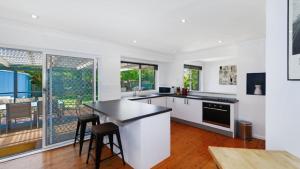 a kitchen with white walls and a large window at Copa Beach House - Family in Copacabana