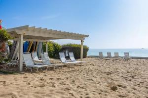eine Gruppe von Stühlen an einem Strand mit einem Pavillon in der Unterkunft Aquareve in Malibu Beach