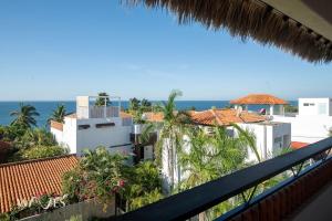 ein Balkon mit Blick auf das Meer und die Gebäude in der Unterkunft Casa Hormiga · Refugio c/vista al mar y Alberca in Puerto Escondido