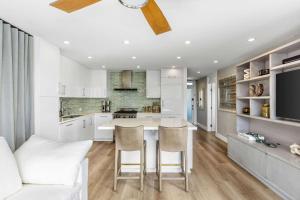 eine Küche mit weißen Schränken und einem Tisch und Stühlen in der Unterkunft Aquareve in Malibu Beach