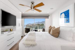 ein weißes Schlafzimmer mit einem großen Bett und einem Deckenventilator in der Unterkunft Aquareve in Malibu Beach + 31 Fotos