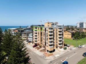 un immeuble situé dans une rue à côté de l'océan dans l'établissement Bright Beachside Escape at The Entrance, à Entrance