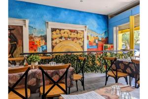 une salle à manger avec des tables et un tableau mural dans l'établissement Bright Beachside Escape at The Entrance, à Entrance