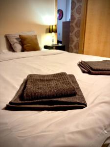 two brown towels are laying on a white bed at Ultracentral Apartment 2 in Braşov