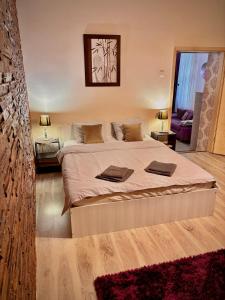a bedroom with a large bed with two towels on it at Ultracentral Apartment 2 in Braşov