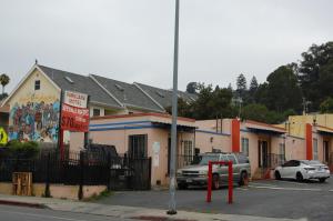 ein Auto, das auf einem Parkplatz vor einem Gebäude geparkt ist in der Unterkunft Parklane Motel in Oakland