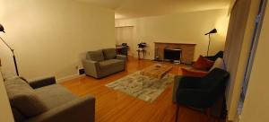 un salon avec un canapé, des chaises et une cheminée dans l'établissement Spacious Family Room with Shared Washroom, à Vancouver