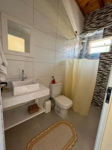 a white bathroom with a sink and a toilet at Flor da Ilha in Estação Quitaúna