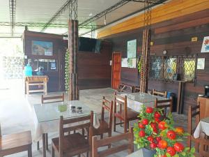 a dining room with tables and chairs and a television at El Colibrí in Puyo