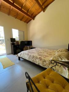 a bedroom with a bed and a chair and a desk at Flor da Ilha in Estação Quitaúna