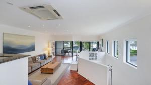 a living room with white walls and a white ceiling at The Point On Cliff - Two Levels and Views in Avoca Beach +11 photos