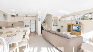 a living room and kitchen with a couch and a table at Sandpiper 4 - Great Location in Avoca Beach