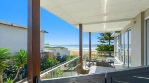 a house with a balcony with a view of the beach at Ocean Sunrise - Magical in Avoca Beach