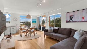 a living room with a couch and a table with chairs at Seaview 5 - Great Beach Views in Avoca Beach