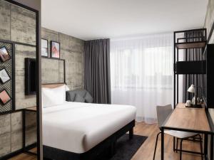 una habitación de hotel con una cama y un escritorio en ibis London Earls Court, en Londres