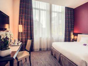 a hotel room with a bed and a desk and a bed and window at Mercure Le Mans Centre in Le Mans +134 photos
