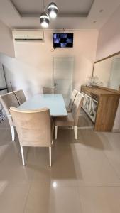 a dining room with a blue table and chairs at Casa ampla e confortável próxima ao shopping pátio in Boa Vista