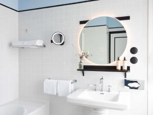 ビアリッツにあるHotel Plaza Biarritz Plage - Handwritten Collectionの洗面台と鏡のある白いバスルーム