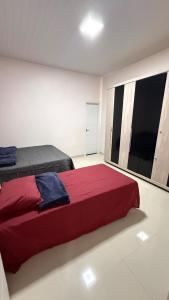 a bedroom with a red bed and a large window at Casa ampla e confortável próxima ao shopping pátio in Boa Vista