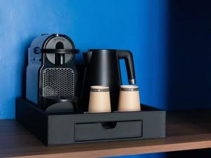 ビアリッツにあるHotel Plaza Biarritz Plage - Handwritten Collectionの棚の上に黒い箱と黒い家電製品が置かれている +97枚の写真