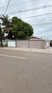 an empty street with a fence and palm trees at Casa ampla e confortável próxima ao shopping pátio in Boa Vista +22 photos