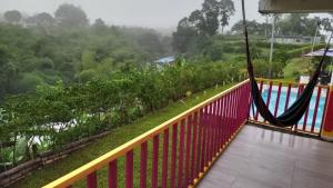 a balcony with a hammock overlooking a river at Finca El Turpial in Ulloa +10 photos