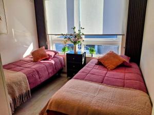 ein Schlafzimmer mit zwei Betten und einem Fenster in der Unterkunft Casa Boutique, Lujo, Seguridad y Privacidad Total in Coquimbo