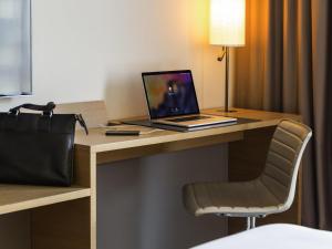 巴塞尔欧洲巴塞尔铂尔曼酒店的坐在酒店房间书桌上的笔记本电脑