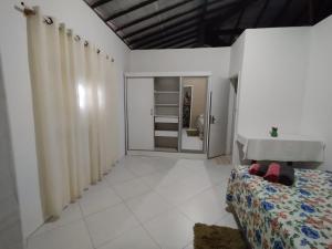 a white room with a bed and a closet at Lumiar Garden Suítes e Chalés em Vilas do Atlântico in Lauro de Freitas