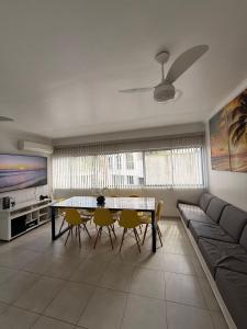 een woonkamer met een bank, een tafel en stoelen bij King Midas in Guarujá