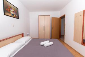 a bedroom with a bed with two towels on it at Am Südhang Gelegen Mit Meerblick in Brovnije