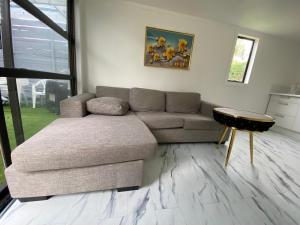 a living room with a couch and a table at 2-bed granny flat near Auckland Airport in Auckland
