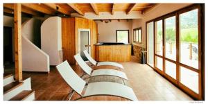 a group of white chairs in a room with windows at Gemütlicher Ferienbungalow Isabena in La Puebla de Roda +9 photos