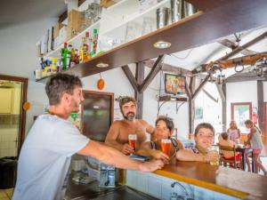 a group of men sitting at a bar at Chalet 34m² 6 Pers - Terrasse et Salon de Jardin - API-1-52-708 in Sainte-Eulalie-en-Born